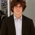 J.D. Porter in a white shirt and dark jacket standing in front of a glass wall.