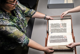 Dot porter works with staff to inspect a manuscript at the Penn libraries