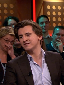 Aron in a blazer on a talk show