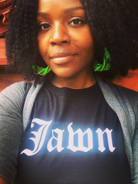 headshot of Prof. Krystal Strong wearing a black shirt with white text that reads "Jawn".